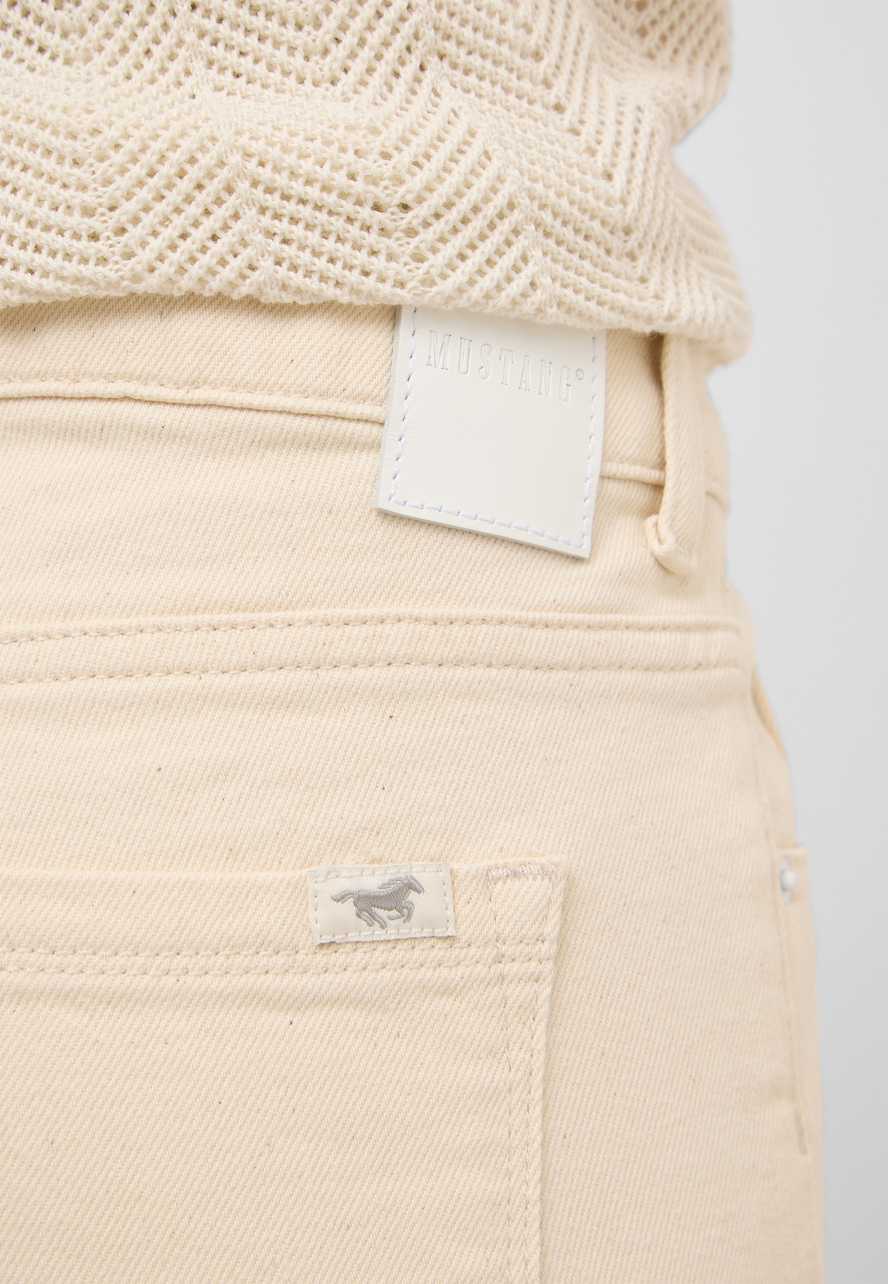 beige Jeans, Gesäßtasche, weiße Etikett, Naht, strukturierter Strick